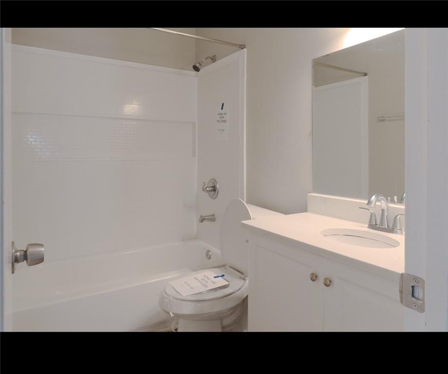 1350 Birdsong Lane Hampton, GA 30228 - Photo 7 of 9 a bathroom with a sink a toilet and a bathtub