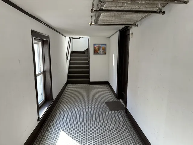 a view of a hallway with wooden floor and stairs