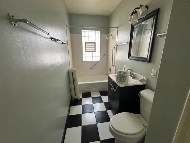 a bathroom with a sink a toilet a mirror and shower