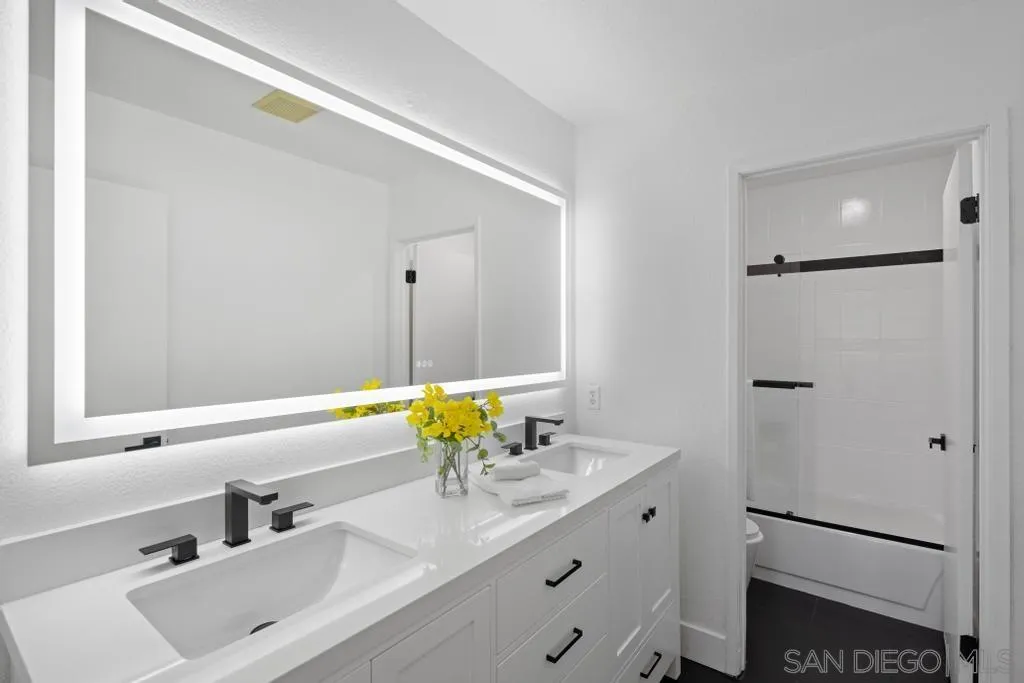 3638 Lorimer Lane Encinitas, CA 92024 - Photo 37 of 72 a bathroom with a granite countertop sink and a mirror