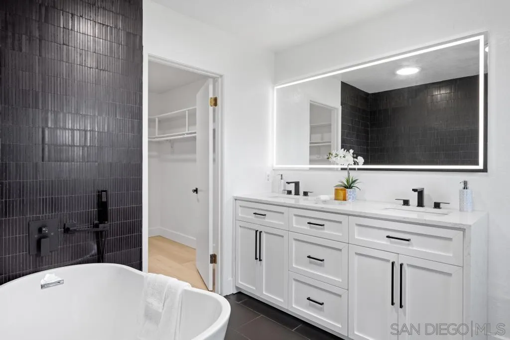 3638 Lorimer Lane Encinitas, CA 92024 - Photo 44 of 72 a bathroom with a sink a large mirror and a bathtub