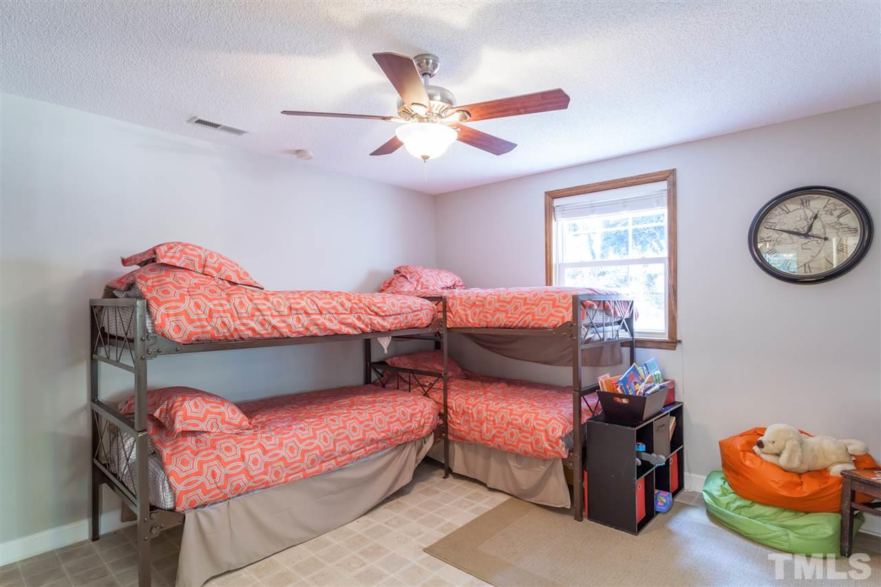 6609 King Lawrence Road Raleigh, NC 27607 - Photo 17 of 25 a bedroom with bed and a chandelier