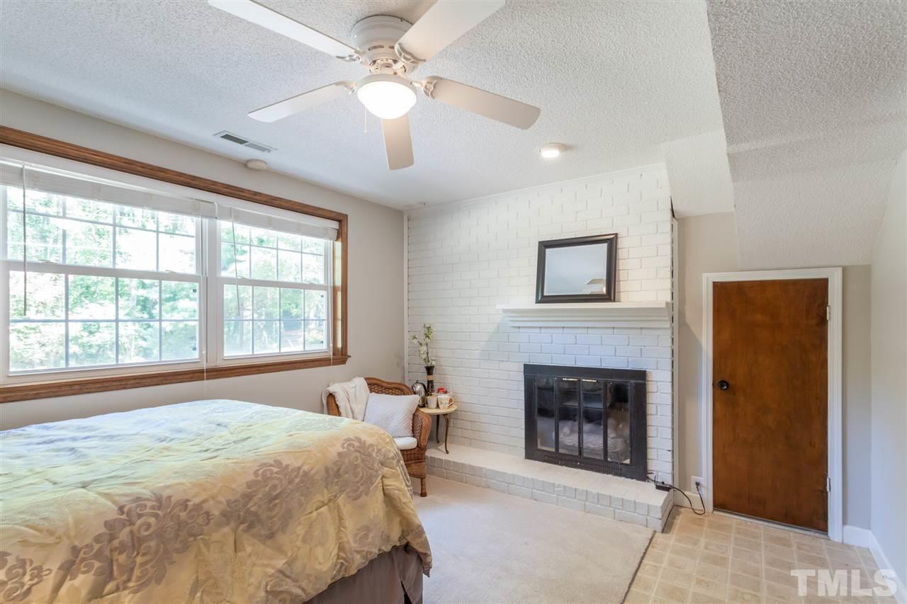 6609 King Lawrence Road Raleigh, NC 27607 - Photo 19 of 25 a spacious bedroom with a bed and a fireplace