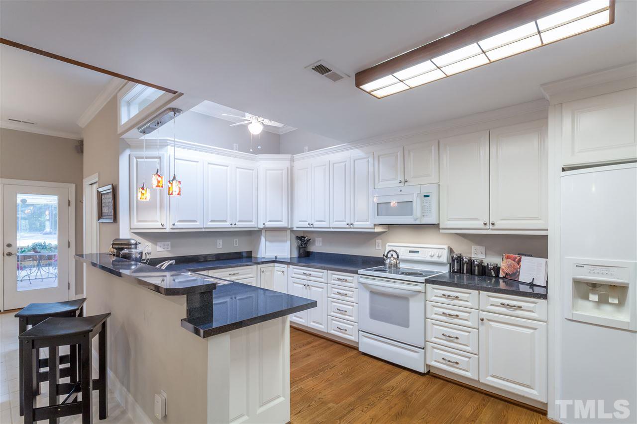 6609 King Lawrence Road Raleigh, NC 27607 - Photo 4 of 25 a kitchen with stainless steel appliances granite countertop a stove a sink and white cabinets