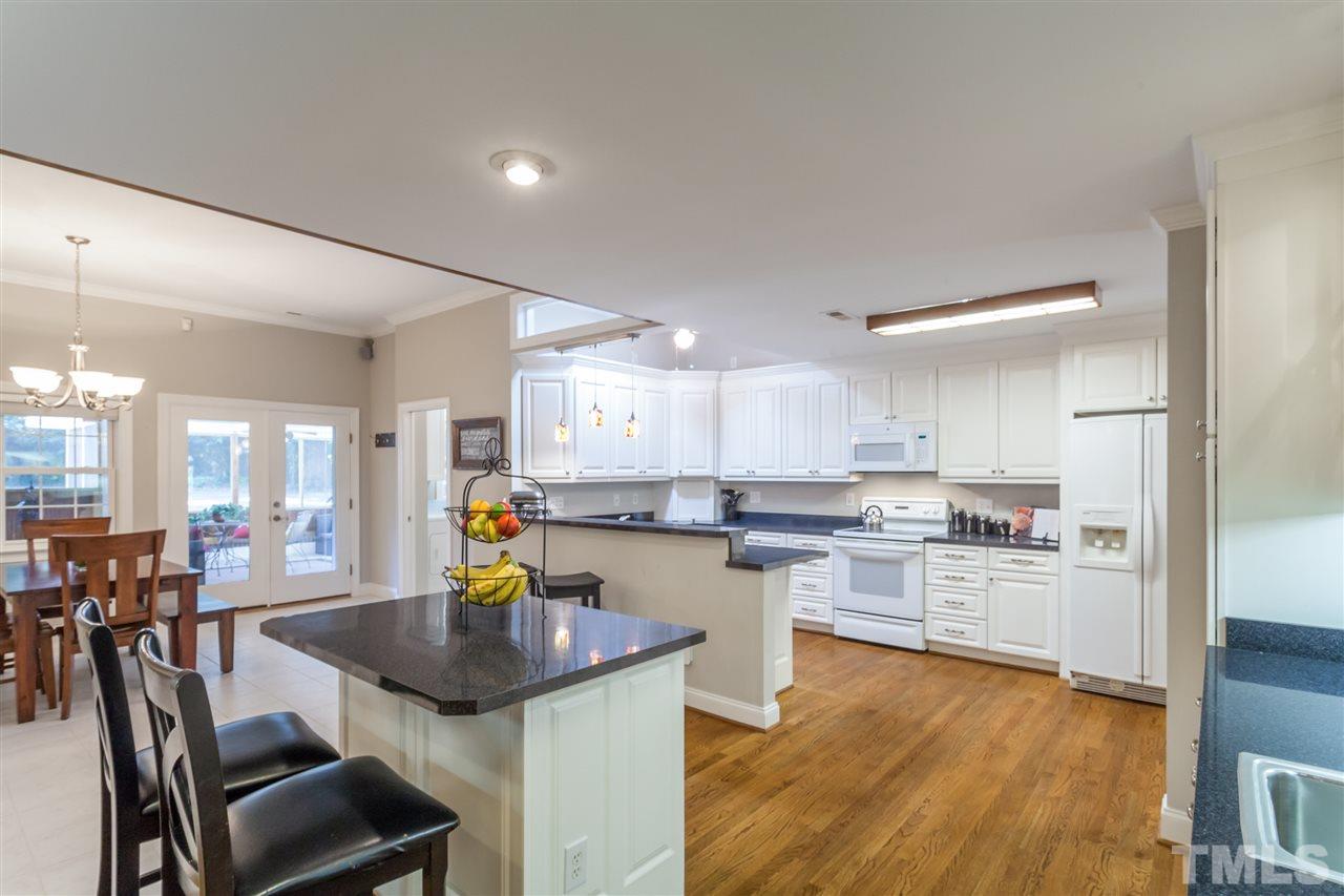 6609 King Lawrence Road Raleigh, NC 27607 - Photo 6 of 25 a kitchen with a table chairs refrigerator and cabinets