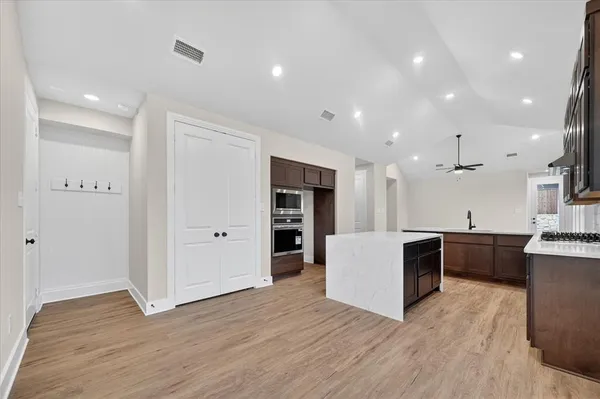 a view of kitchen with kitchen island wooden floor center island and appliances