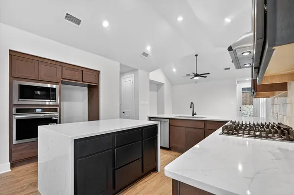 a kitchen with a sink stainless steel appliances and cabinets