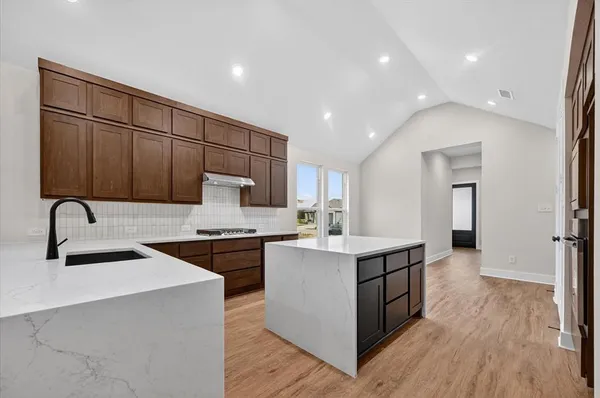 a kitchen with kitchen island stainless steel appliances a sink stove and refrigerator