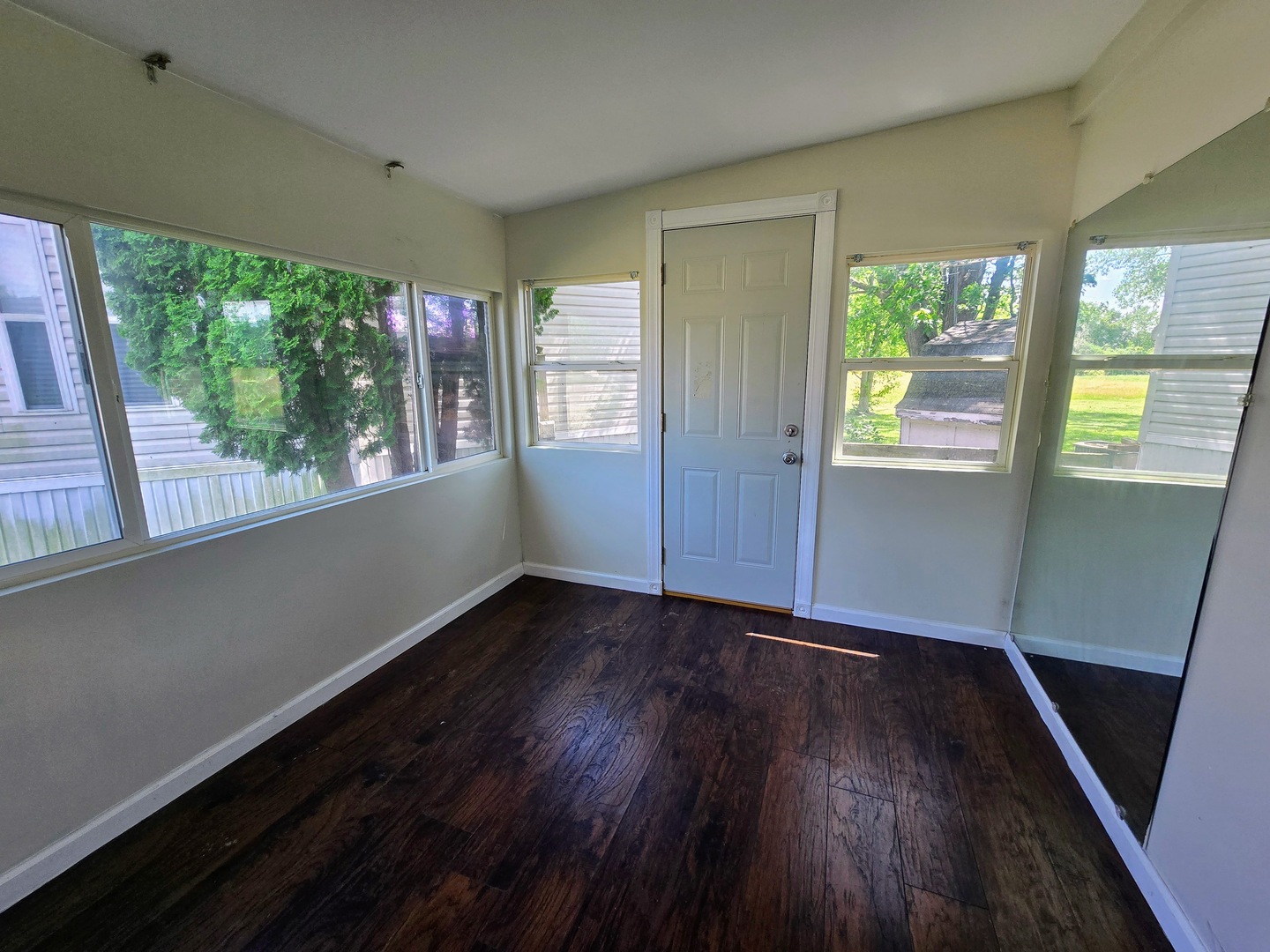 182 Windward Road Lakemoor, IL 60051 - Photo 3 of 22 a view of an empty room with wooden floor and a window
