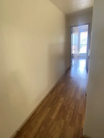 a view of a hallway with wooden floor