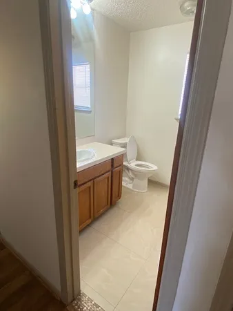 a bathroom with a granite countertop toilet sink and mirror