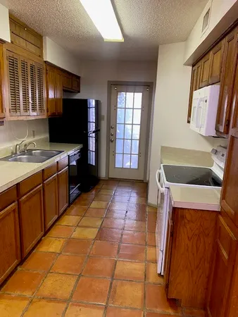 a kitchen with a sink a stove and a microwave