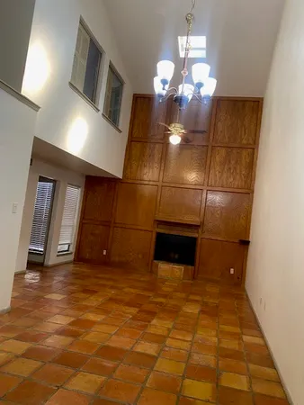 a view of a livingroom with fireplace and chandelier