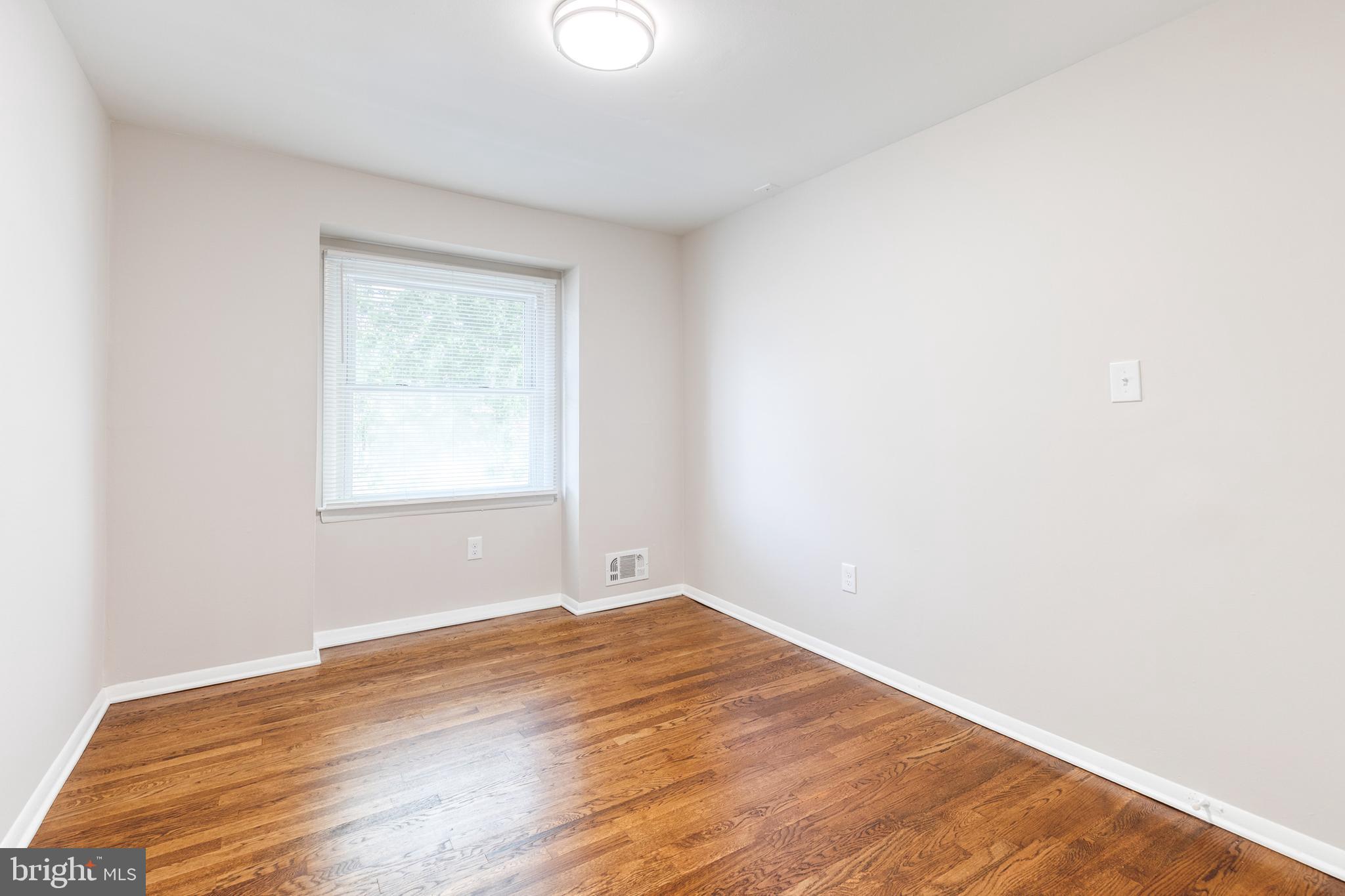 5649 Utrecht Road Baltimore, MD 21206 - Photo 26 of 42 an empty room with wooden floor and windows