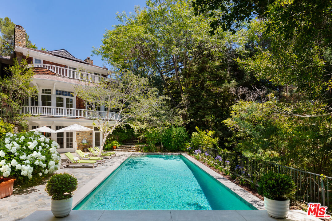 2041 Mandeville Canyon Road Los Angeles, CA 90049 - Photo 2 of 46 a front view of a house with garden