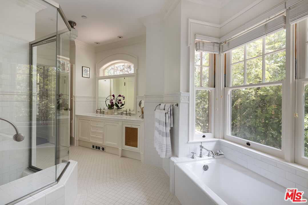 2041 Mandeville Canyon Road Los Angeles, CA 90049 - Photo 27 of 46 a bathroom with a bathtub a sink and a mirror