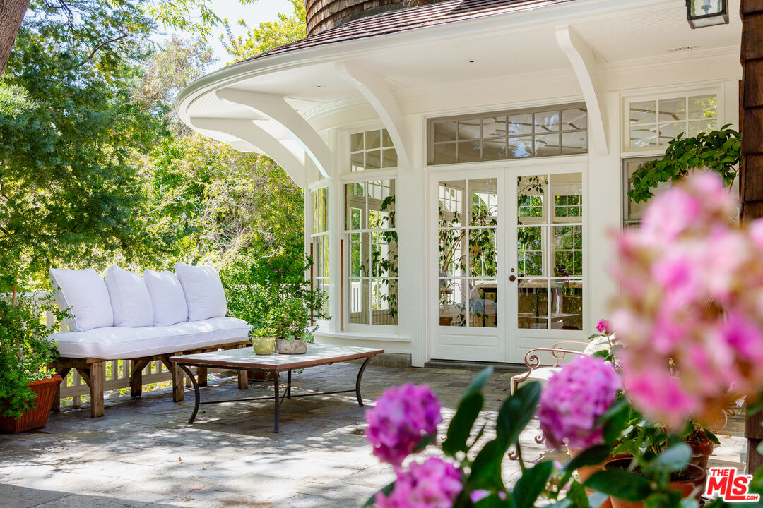 2041 Mandeville Canyon Road Los Angeles, CA 90049 - Photo 39 of 46 a view of a patio with table and chairs and potted plants