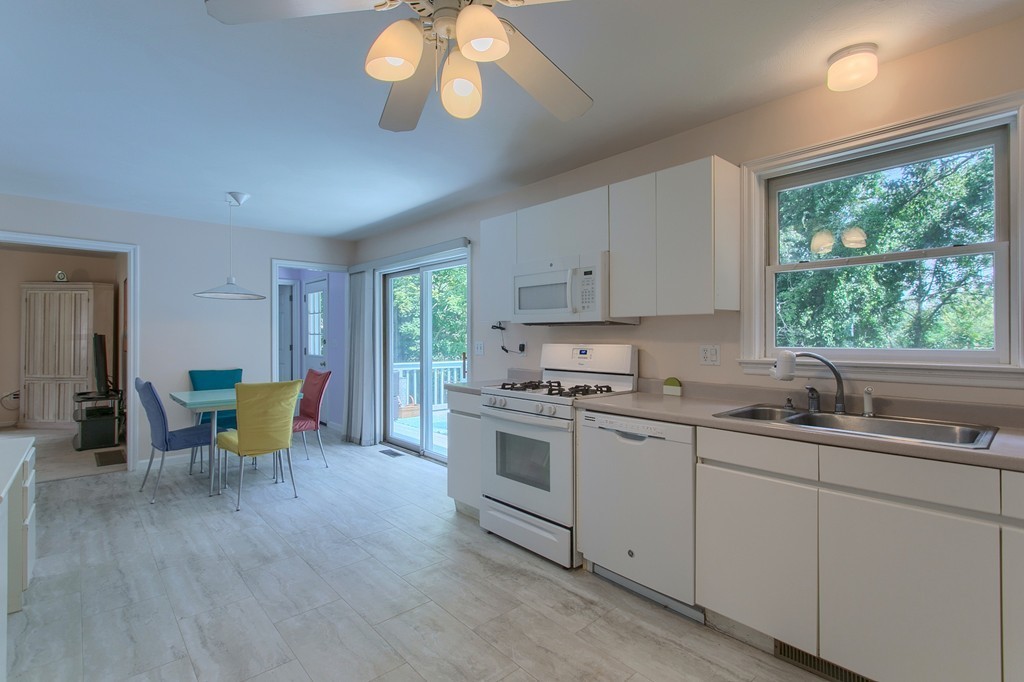 109 North Road Chelmsford, MA 01824 - Photo 11 of 30 a kitchen with stainless steel appliances granite countertop a stove a sink dishwasher and white cabinets with wooden floor
