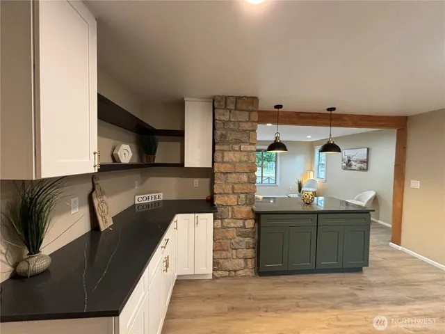 a living room with furniture kitchen view and a wooden floor