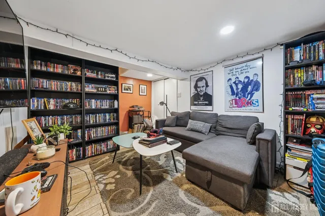 a living room with furniture and a book shelf