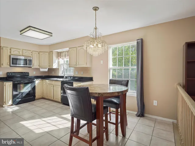 a view of a livingroom with a chandelier fan and windows