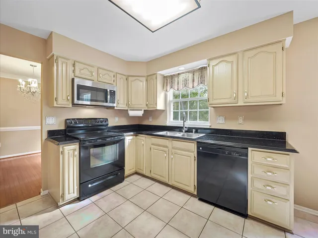 a kitchen with granite countertop a refrigerator stove and microwave