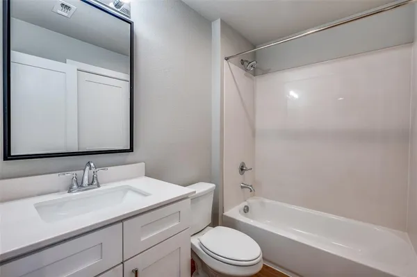 a bathroom with a granite countertop sink a toilet and shower