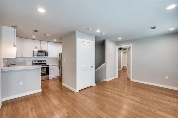 a kitchen with stainless steel appliances granite countertop a refrigerator and a stove top oven