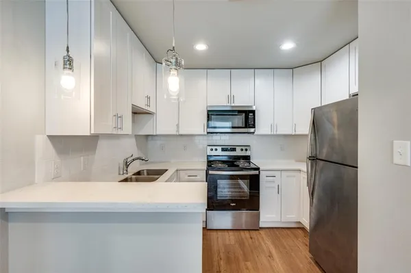 a kitchen with white cabinets and stainless steel appliances