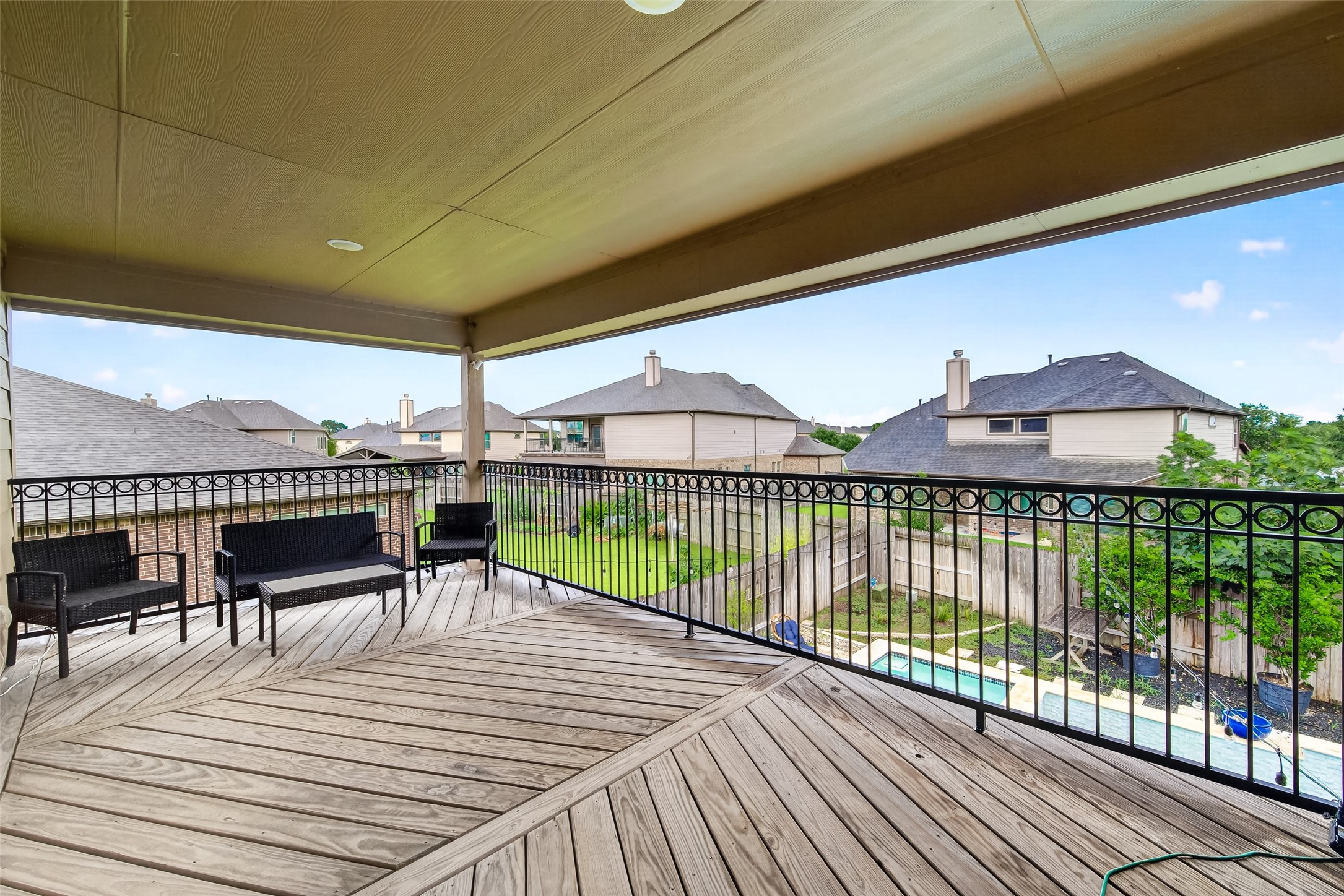 25611 Ellis Ridge Court Katy, TX 77494 - Photo 27 of 49 Spacious covered balcony with elegant railing overlooking a fenced backyard and pool, perfect for outdoor relaxation and entertaining.