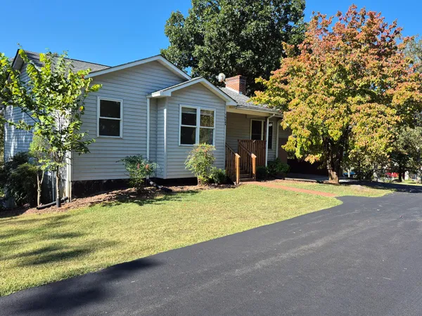 a front view of house with yard and trees around