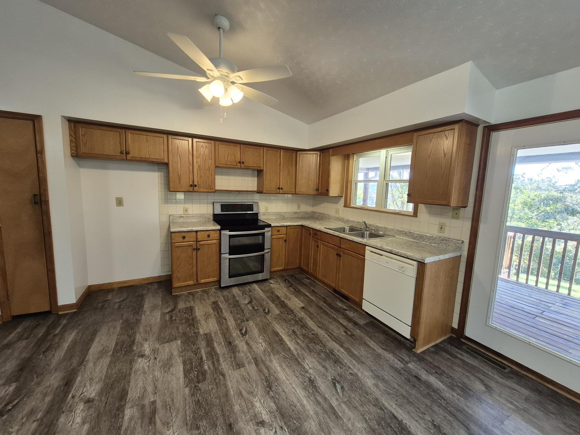 10048 Moneta Road Bedford, VA 24523 - Photo 17 of 51 a kitchen with wooden floors and white appliances