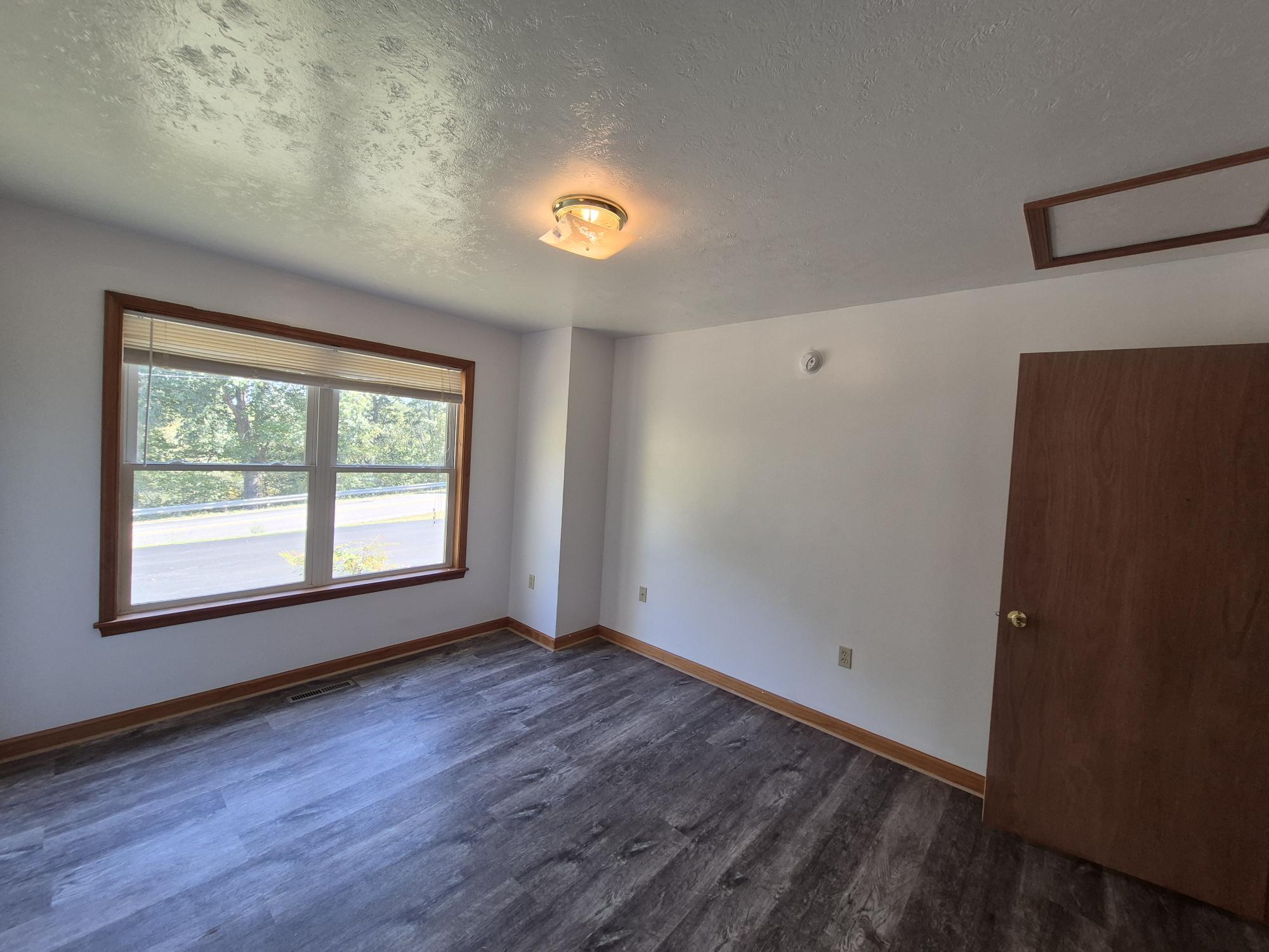 10048 Moneta Road Bedford, VA 24523 - Photo 18 of 51 a view of an empty room with wooden floor and a window