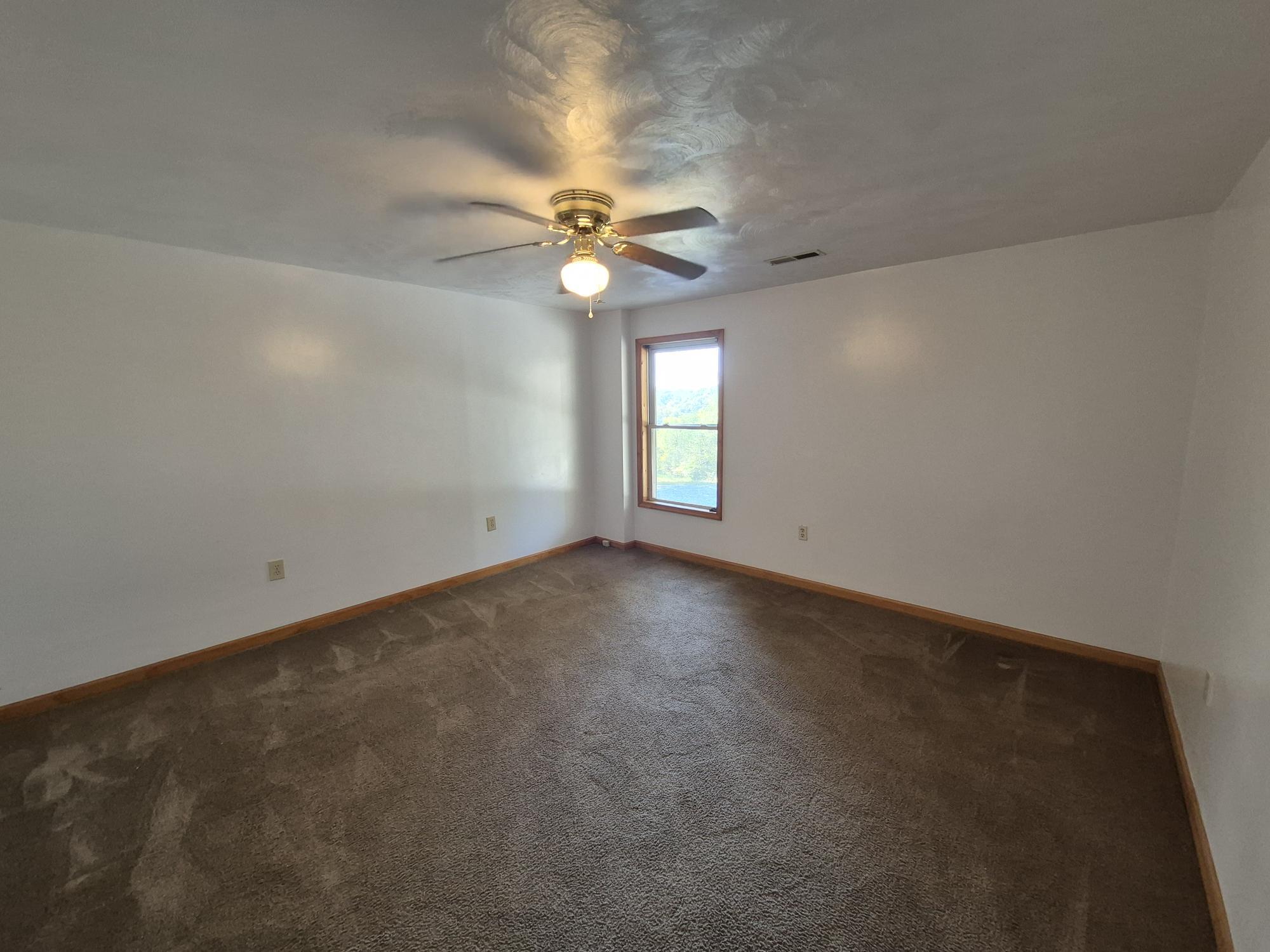 10048 Moneta Road Bedford, VA 24523 - Photo 25 of 51 an empty room with a window and a fan