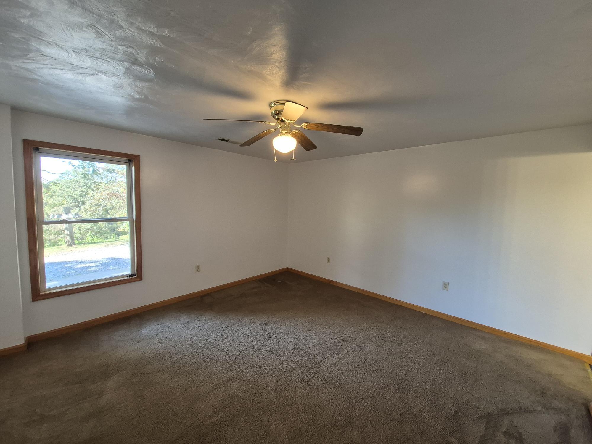10048 Moneta Road Bedford, VA 24523 - Photo 26 of 51 an empty room with a window and a ceiling fan