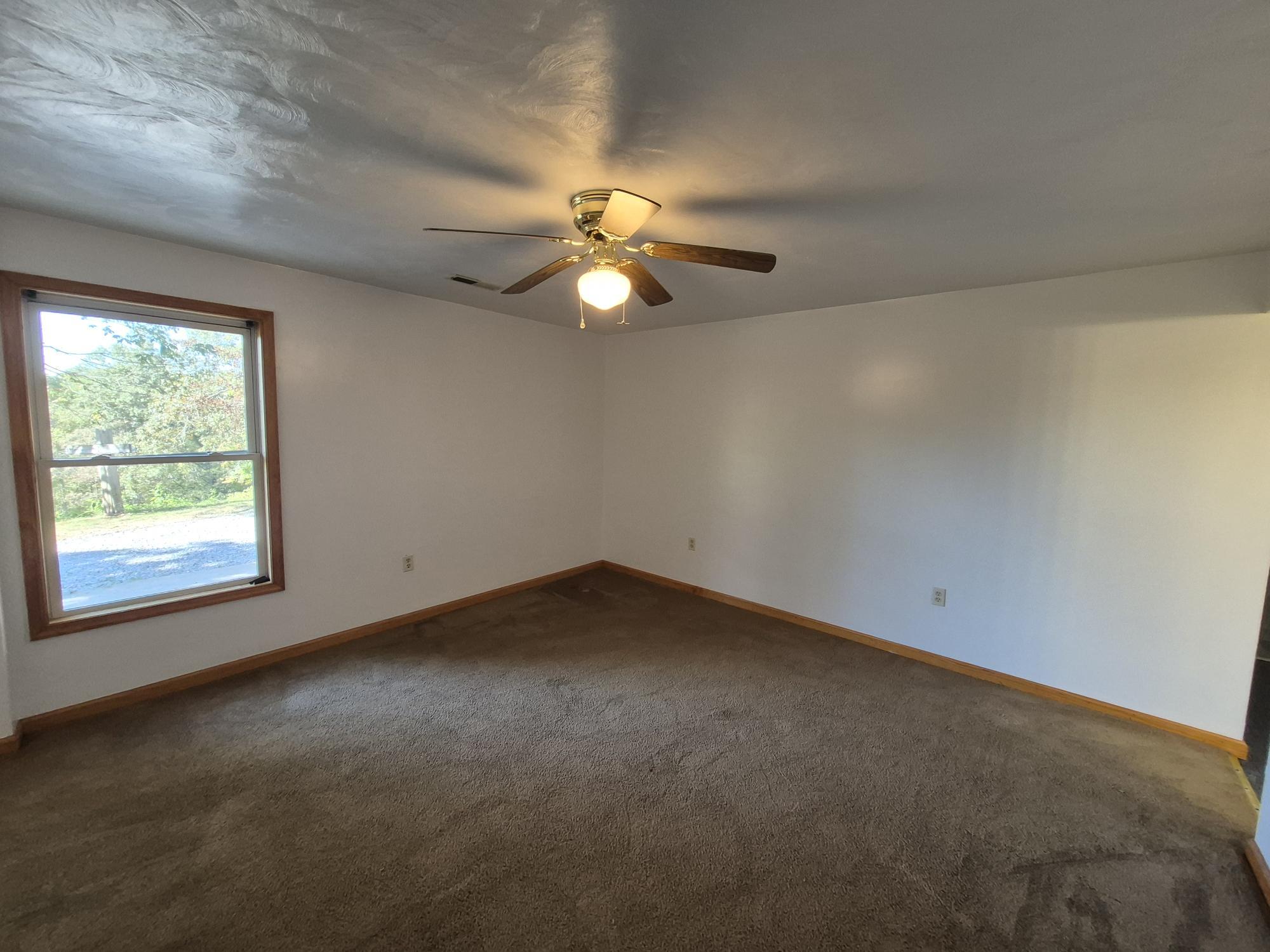 10048 Moneta Road Bedford, VA 24523 - Photo 27 of 51 an empty room with a window and a fan