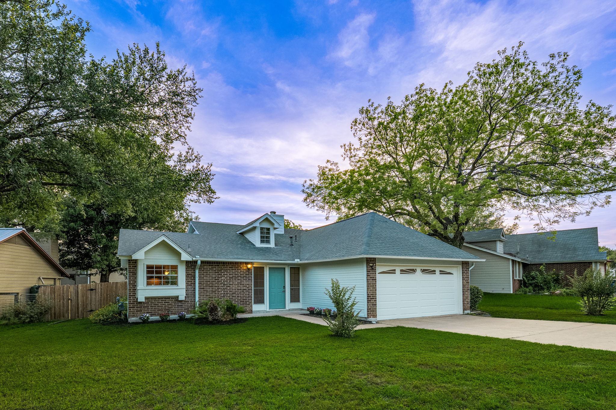 4815 Transit Circle Austin, TX 78727 - Photo 1 of 35 Charming ranch-style exterior featuring a classic brick façade, light siding, and a cheerful light turquoise front door.