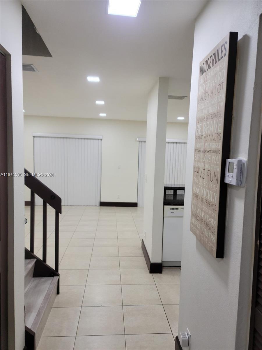 17401 Southwest 140th Court Miami, FL 33177 - Photo 12 of 42 a view of a refrigerator in kitchen and an empty room with windows