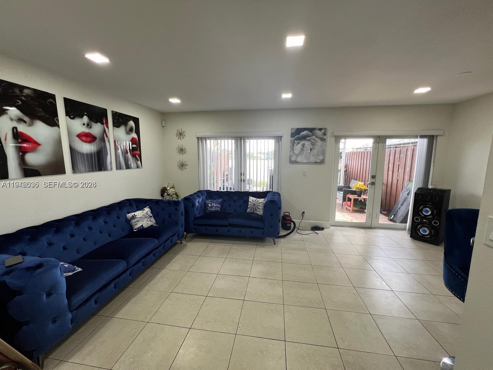 17401 Southwest 140th Court Miami, FL 33177 - Photo 19 of 42 a living room with furniture and a gym machine with rug