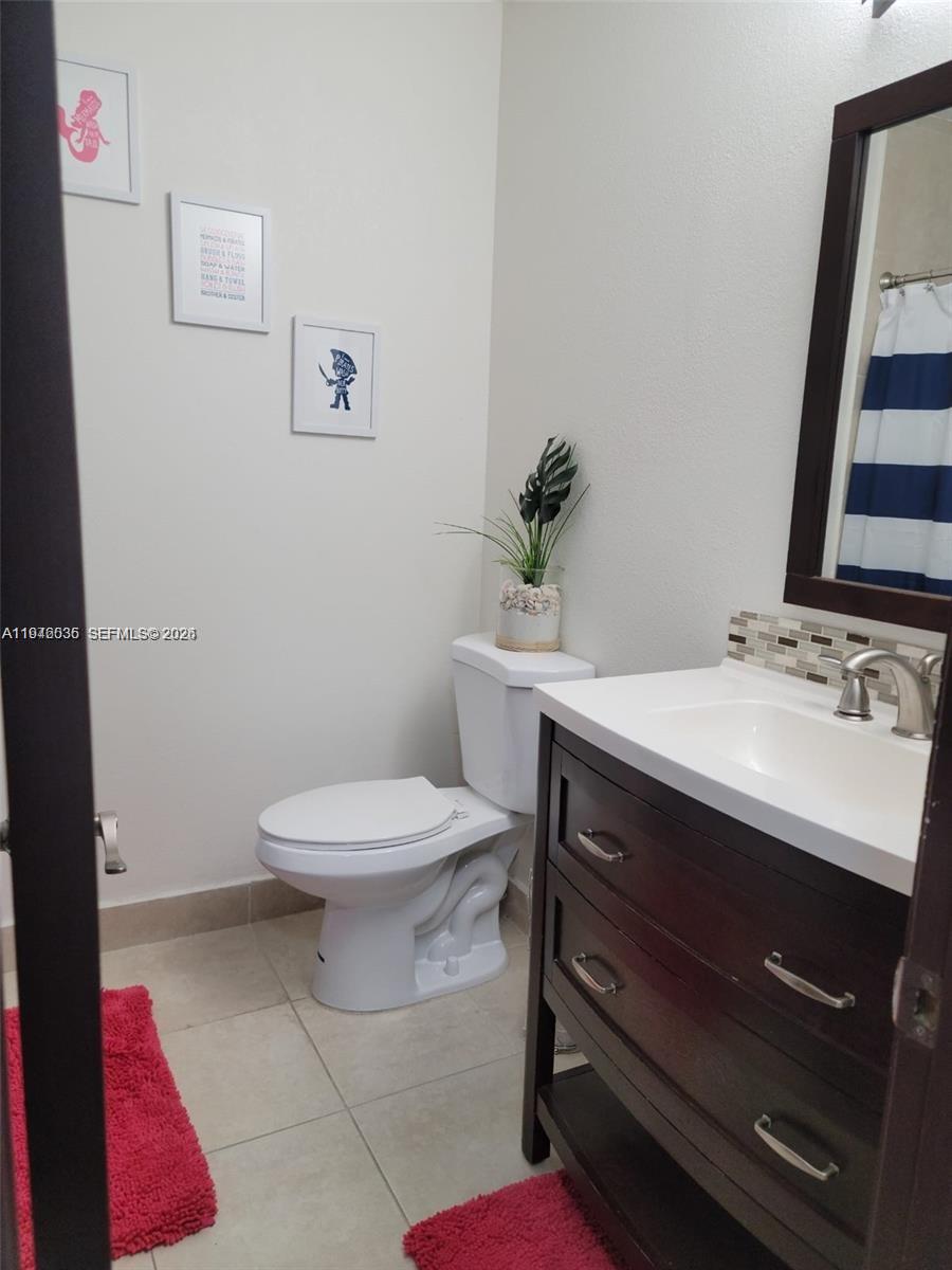17401 Southwest 140th Court Miami, FL 33177 - Photo 27 of 42 a bathroom with a sink mirror vanity and toilet