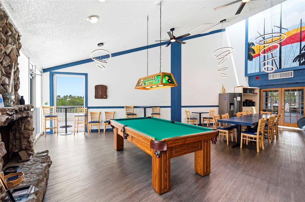 14800 Walsingham Road, Unit 702 Largo, FL 33774 - Photo 40 of 42 a dining room with wooden floor a chandelier a wooden table and chairs