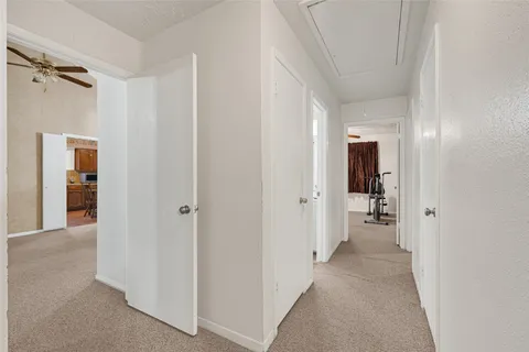 a view of a room with a hallway and wooden shelves