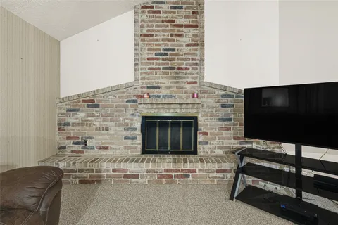 a living room with a fireplace and a flat screen tv