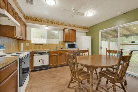 a kitchen with stainless steel appliances granite countertop a stove a sink a microwave a dining table and chairs
