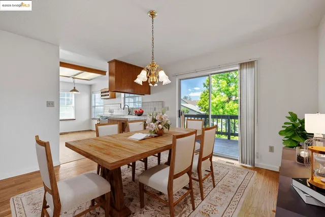 a dining room with furniture a chandelier and wooden floor