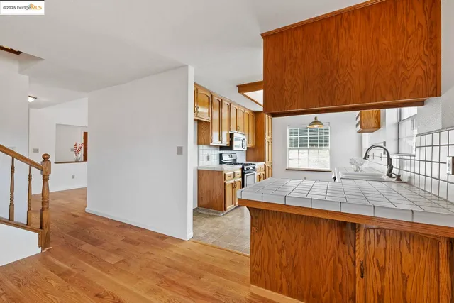 a kitchen with stainless steel appliances granite countertop a sink window and cabinets
