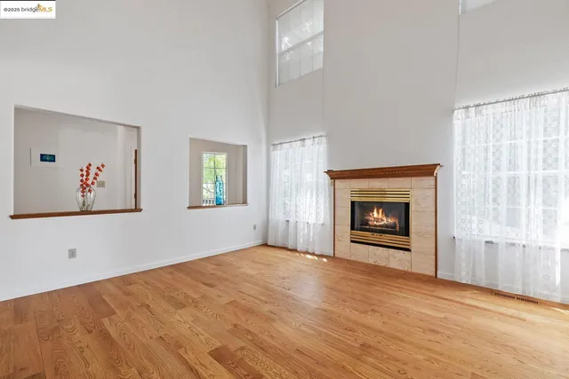 a view of an empty room with a window and fireplace