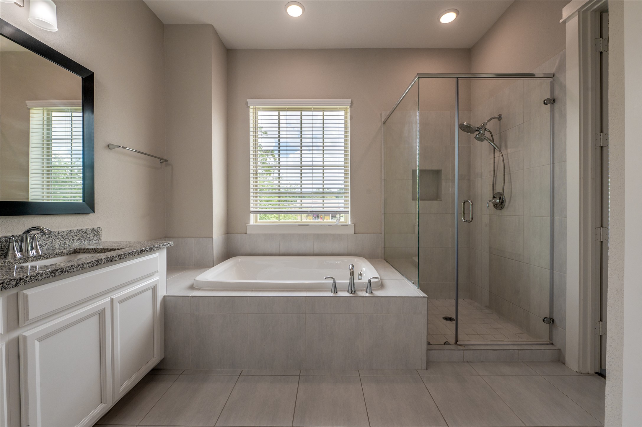 963 Lilly Flower Lane Houston, TX 77091 - Photo 21 of 28 Primary bathroom with double sinks, standalone shower, and soaking tub