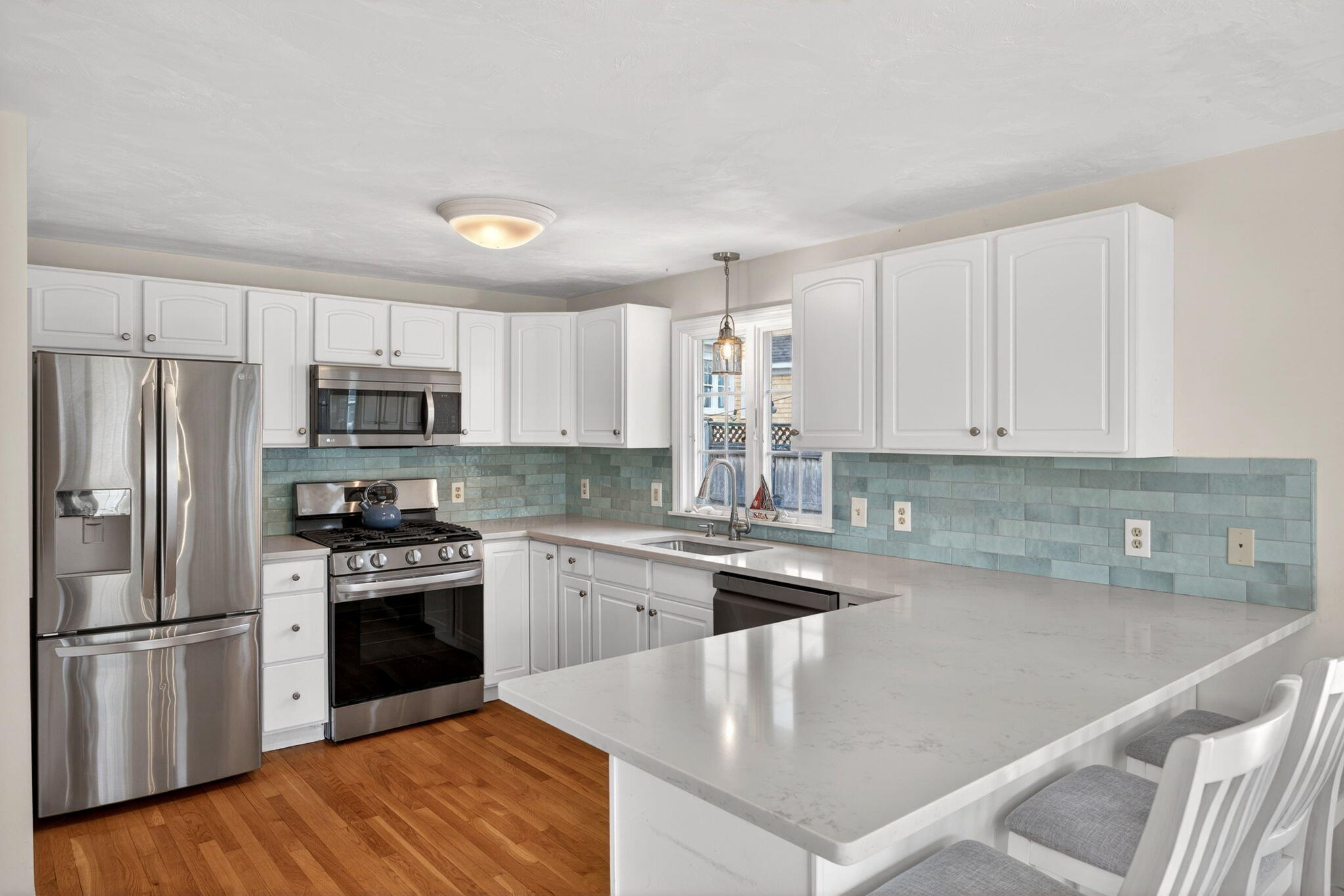 35 Pine Tree Road South Chatham, MA 02659 - Photo 8 of 39 a kitchen with stainless steel appliances granite countertop a stove a sink dishwasher a refrigerator and white cabinets with wooden floor