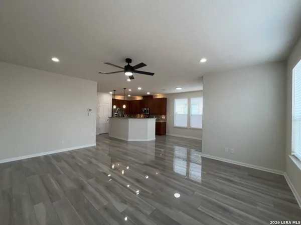 a view of a room with a wooden floor and chandelier